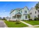 Two-story light green house with a front porch, landscaped yard, and walkway at 946 Crystal Water Way, Myrtle Beach, SC 29579