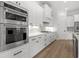 Modern kitchen with white cabinets, marble countertops, and stainless steel appliances at 946 Crystal Water Way, Myrtle Beach, SC 29579