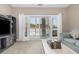 Living room with grey couch and view of balcony overlooking snow covered landscape at 112 Cypress Point Ct. # 202, Myrtle Beach, SC 29579