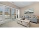 Living room with grey couch and view of balcony overlooking snow covered landscape at 112 Cypress Point Ct. # 202, Myrtle Beach, SC 29579