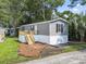 Gray mobile home with a wooden deck and stairs at 1533 Sand Dollar Ln., Garden City Beach, SC 29576