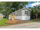 Gray mobile home with a deck and landscaping at 1533 Sand Dollar Ln., Garden City Beach, SC 29576