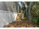Side exterior view of a gray home with a wooden stairway and new landscaping at 1533 Sand Dollar Ln., Garden City Beach, SC 29576
