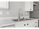 Close-up of the stainless steel kitchen sink and white marble-look countertop at 1533 Sand Dollar Ln., Garden City Beach, SC 29576
