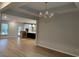 Open-concept dining area with modern chandelier and hardwood floors, seamlessly connecting to the kitchen at 25 Northbrook Dr, Murrells Inlet, SC 29576