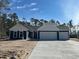 Charming new construction home with a three car garage, blue siding, and white trim at 25 Northbrook Dr, Murrells Inlet, SC 29576