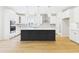 Bright kitchen boasts white cabinets, patterned backsplash, black island with quartz countertop, and pendant lighting at 25 Northbrook Dr, Murrells Inlet, SC 29576
