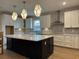 Modern kitchen with a large island, white cabinets, stainless steel appliances, and geometric tile backsplash at 25 Northbrook Dr, Murrells Inlet, SC 29576