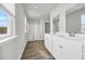 Bright bathroom boasts double vanity, shower, and grey flooring at 274 Columbus St., Conway, SC 29526