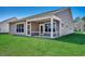 Backyard featuring a screened porch, large windows and green grass at 35 Northbrook Dr, Murrells Inlet, SC 29576