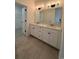 Bathroom featuring double sink vanity, granite countertop, modern lighting, and hardwood style flooring with access to closet at 35 Northbrook Dr, Murrells Inlet, SC 29576