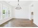 Open dining room featuring hardwood floors, large windows, and a modern chandelier at 35 Northbrook Dr, Murrells Inlet, SC 29576