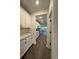 Hallway with white cabinets and drawers on the left side and view of living room and windows in the distance at 35 Northbrook Dr, Murrells Inlet, SC 29576