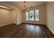 Sun-drenched living room featuring dark wood floors and a decorative chandelier at 35 Northbrook Dr, Murrells Inlet, SC 29576