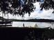 Waterfront scene with a covered boat, pier, and American flag surrounded by lush landscaping at 35 Northbrook Dr, Murrells Inlet, SC 29576