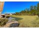 Large backyard with patio, lush lawn, and water view at 409 Carrick Loop, Longs, SC 29568