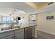 Open-concept kitchen boasts stainless steel appliances and smooth granite counters, overlooking the living area at 4103 N Ocean Blvd. # 504, North Myrtle Beach, SC 29582