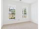 Bright bedroom features plush carpet and large windows offering views of the landscaped neighborhood at 45 Northbrook Dr, Murrells Inlet, SC 29576