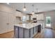 A modern kitchen boasts white cabinets, stainless appliances, and a large island with quartz countertops at 45 Northbrook Dr, Murrells Inlet, SC 29576