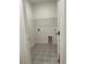 A modern laundry room featuring patterned tile floor, utility sink connection, and storage shelf at 45 Northbrook Dr, Murrells Inlet, SC 29576