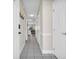 Neutral-toned hallway with tiled floors, coat rack, and white doors at 4846 Carnation Circle # 203, Myrtle Beach, SC 29577