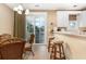 Kitchen with breakfast bar and adjacent dining area with glass table and wicker chairs at 4919 Cinzia Ln. # 6-B, North Myrtle Beach, SC 29582