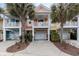 Inviting coastal townhome with two-story design, attached garage, and palm trees at 4919 Cinzia Ln. # 6-B, North Myrtle Beach, SC 29582