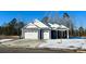 Two-car garage, white and blue exterior, partially snow covered lawn at 536 Sheepbridge Way, Loris, SC 29568