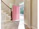 Bright entryway with pink door, tile floor, and wooden staircase at 55 Pineberry Dr., Georgetown, SC 29440