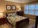 Comfortable bedroom with wood furniture and large window at 601 N Hillside Dr. # 4235, North Myrtle Beach, SC 29582