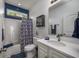 Bright bathroom featuring a white vanity, shower/tub, and blue walls at 608 Surfsong Way # 608, North Myrtle Beach, SC 29582