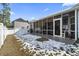 Screened porch and fenced backyard with a partially snow covered lawn at 901 Queensferry Ct., Conway, SC 29526