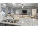 Open concept living room with tray ceilings, ceiling fan, comfortable seating, and seamless kitchen access at 901 Queensferry Ct., Conway, SC 29526
