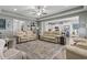 Open concept living room with tray ceilings, ceiling fan, comfortable seating, and seamless kitchen access at 901 Queensferry Ct., Conway, SC 29526