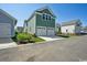 Two-car garage in modern home with green siding and well manicured lawn at 1816 Tryon Dr, Myrtle Beach, SC 29588