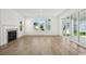 Bright living room with a fireplace, large windows, sliding glass doors, and light wood flooring at 1816 Tryon Dr, Myrtle Beach, SC 29588