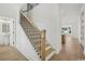 Bright entryway with wooden staircase featuring black iron railings, complemented by light wood flooring and white walls at 1816 Tryon Dr, Myrtle Beach, SC 29588