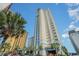 High rise condo building with modern architecture, palm trees, and blue accents on a sunny day at 2504 North Ocean Blvd. # 436, Myrtle Beach, SC 29577