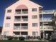Rear view of a three-story building with multiple balconies at 2710 Ocean Blvd. S # 406, Myrtle Beach, SC 29577