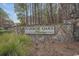 Stone sign at Harbor Oaks Marina shows neighborhood entrance among the wooded landscape in a serene setting at 301 Crossing Ct., Myrtle Beach, SC 29588