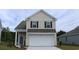 Two-story house with beige siding, white garage door, and landscaping at 4024 Smokey Dr, Conway, SC 29526