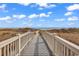 Beach walkway leading to a beautiful beach with blue skies and ocean views at 415 Ocean Creek Dr. # 2139, Myrtle Beach, SC 29572