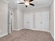 Bedroom with neutral walls and carpet displaying two closet doors and an open doorway to the adjacent room at 626 Lorenzo Dr. # 626, North Myrtle Beach, SC 29582