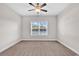 This is a spacious bedroom with a ceiling fan, plush carpeting, and a large window with a scenic view at 626 Lorenzo Dr. # 626, North Myrtle Beach, SC 29582