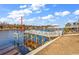 Waterfront dock with weathered wood and a boat lift on a sunny day with blue skies and cloud accents at 626 Lorenzo Dr. # 626, North Myrtle Beach, SC 29582