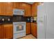 White appliances and wood cabinets in this galley-style kitchen at 1313 Villa Marbella Ct. # 101, Myrtle Beach, SC 29572