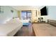 A cozy bedroom features two beds, a balcony view, and a mounted TV for relaxing evenings at 1501 S Ocean Blvd. # 811, Myrtle Beach, SC 29577