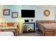 Comfortable living area featuring a flatscreen TV, rattan mirror, and a convertible futon at 1501 S Ocean Blvd. # 811, Myrtle Beach, SC 29577