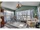 Cozy sunroom features large windows, comfortable seating, and a chandelier at 1579 Southwood Dr., Surfside Beach, SC 29575