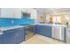 Modern kitchen with blue tile backsplash, stainless steel appliances, and white and blue cabinetry at 306 River Rock Ln. # 1304, Murrells Inlet, SC 29576